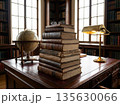 Stacked antique books on wooden desk with globe and lamp in classic library interior 135630066