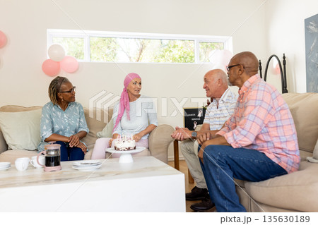 Senior friends enjoying conversation and cake at home during cozy gathering Senior friends enjoying conversation and cake at home during cozy gathering 135630189
