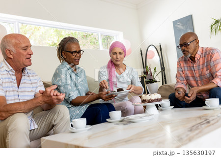 Sharing joyful conversation, senior friends having cake and coffee together at home Sharing joyful conversation, senior friends having cake and coffee together at home 135630197
