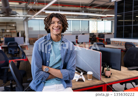 In office, African American man standing confidently, feeling relaxed and smiling 135630222