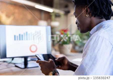 Business professional analyzing data on tablet and computer in modern office 135630247