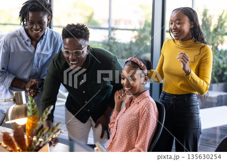 African American colleagues collaborating on project at office, smiling and engaged 135630254