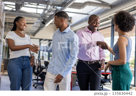 Colleagues in office shaking hands and smiling, building professional relationships Colleagues in office shaking hands and smiling, building professional relationships 135630442