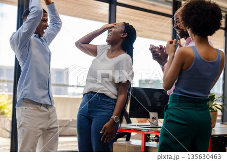 Colleagues celebrating success in office, smiling and clapping with excitement 135630463
