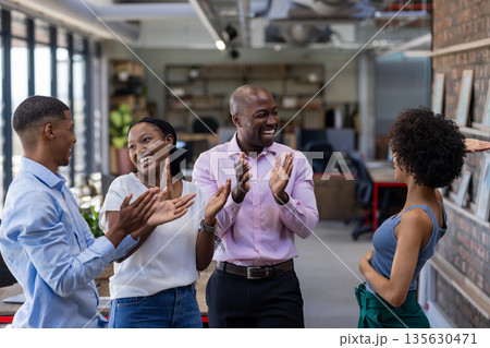 Colleagues in office clapping and celebrating success with joyful expressions Colleagues in office clapping and celebrating success with joyful expressions 135630471