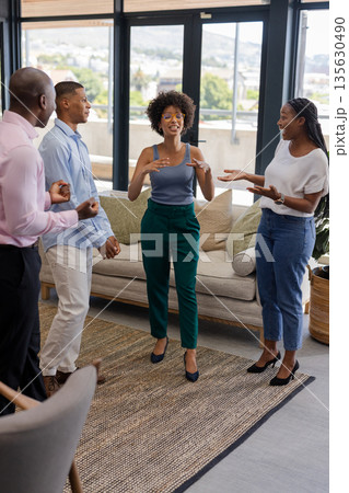 Colleagues in office laughing and discussing ideas during casual team meeting Colleagues in office laughing and discussing ideas during casual team meeting 135630490