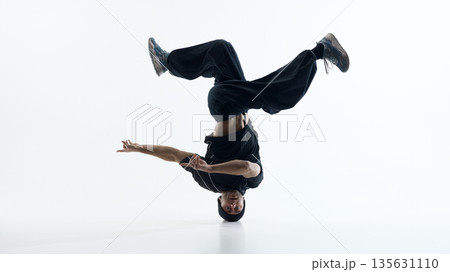 Breakdance head supported freeze with extended limbs isolated on white background. Breakdance head supported freeze with extended limbs isolated on white background. 135631110