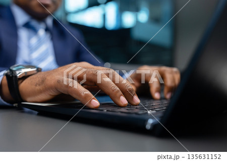 African American executive typing on laptop in contemporary office 135631152