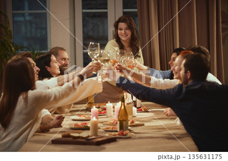 Friends in their thirties enjoying relaxed wine evening together. 135631175