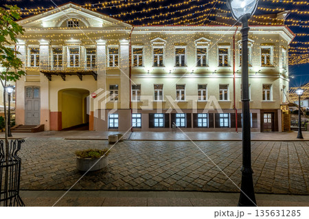 Exterior of a classic hostel building at night with festive street lights 135631285