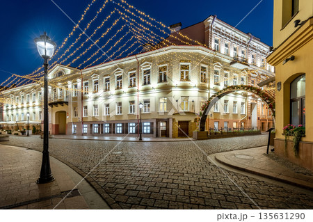 Night exterior of a grand historic building on a lit cobblestone street Night exterior of a grand historic building on a lit cobblestone street 135631290