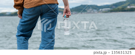 ペットボトルの水を持っている人 135631325