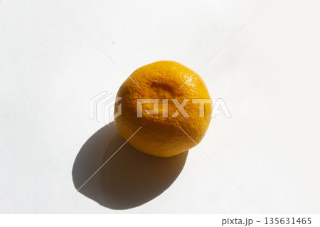 It is a tangerine lying on a white background. It is a tangerine lying on a white background. 135631465