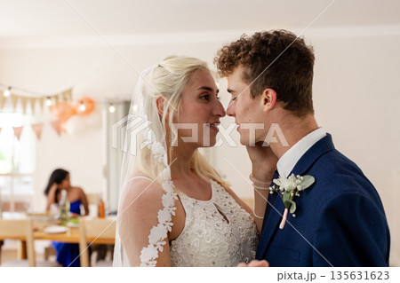 Bride and groom looking into each other's eyes during wedding celebration 135631623