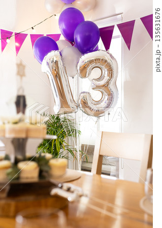 Celebrating 13th birthday with silver balloons and cupcakes in decorated room Celebrating 13th birthday with silver balloons and cupcakes in decorated room 135631676