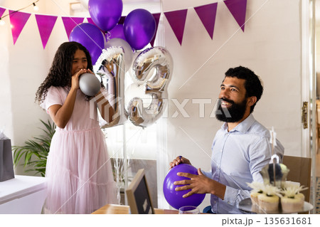 Father and daughter celebrating 13th birthday with balloons and decorations at home 135631681