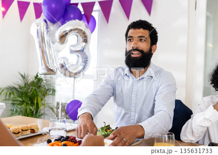 Man celebrating birthday at party with balloons and festive decorations indoors 135631733