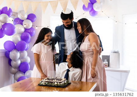 Family celebrating bar mitzvah together with cake and decorations at home 135631762