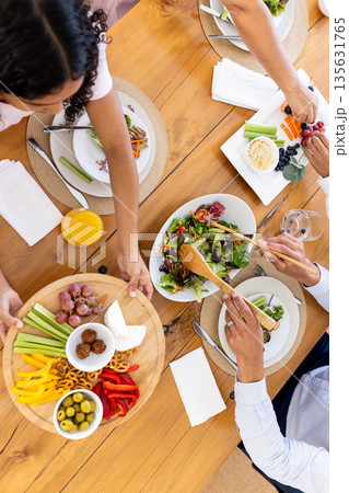 Sharing vibrant vegetarian meal with friends, enjoying fresh salads and appetizers Sharing vibrant vegetarian meal with friends, enjoying fresh salads and appetizers 135631765