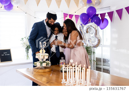 Celebrating bar mitzvah, family sharing joyful moment with cake and decorations together Celebrating bar mitzvah, family sharing joyful moment with cake and decorations together 135631767