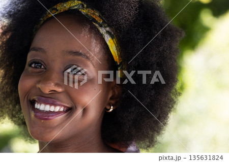 Smiling African American woman outdoors, enjoying sunny day with friends Smiling African American woman outdoors, enjoying sunny day with friends 135631824