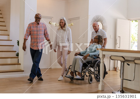 Walking together, senior friends having conversation at home, smiling and talking 135631901
