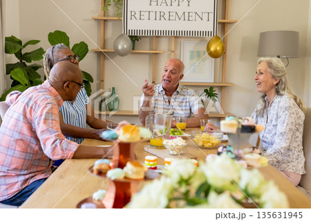 Celebrating retirement at home, senior friends having conversation and snacks together Celebrating retirement at home, senior friends having conversation and snacks together 135631945