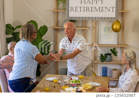 Celebrating retirement, senior friends having joyful conversation and refreshments at home 135632007