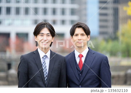 オフィス街で微笑むスーツの日本人男性 135632110