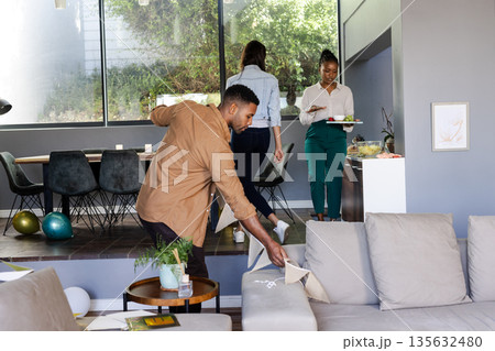 Friends preparing for celebration at home, arranging decorations and setting table 135632480