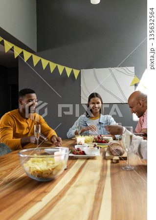 Friends enjoying snacks and drinks at home, celebrating with laughter and joy Friends enjoying snacks and drinks at home, celebrating with laughter and joy 135632564