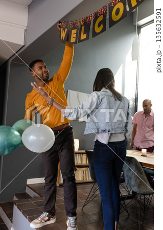 Friends decorating home with balloons and welcome banner for celebration Friends decorating home with balloons and welcome banner for celebration 135632591