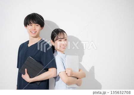 タブレットを持つ爽やかな看護師イメージの若い男女 新卒採用や転職の求人などに タブレットを持つ爽やかな看護師イメージの若い男女 新卒採用や転職の求人などに 135632708