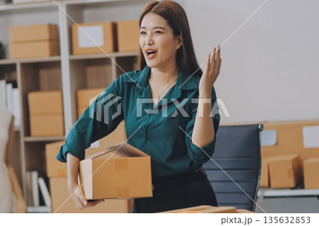 Starting small businesses SME owners female entrepreneurs check online orders to prepare to pack the boxes, sell to customers, sme business ideas online. Starting small businesses SME owners female entrepreneurs check online orders to prepare to pack the boxes, sell to customers, sme business ideas online. 135632853