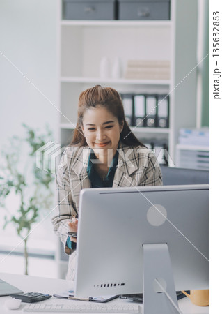 Determined asian businesswoman works late in a modern office, confidently analyzing data on her laptop, embodying success and professionalism with a smile Determined asian businesswoman works late in a modern office, confidently analyzing data on her laptop, embodying success and professionalism with a smile 135632883