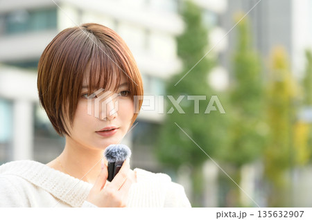 オフィス街でピンマイクを持つショートカットの女性 135632907