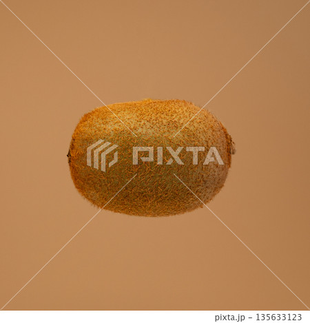 A kiwi fruit is shown in the air 135633123