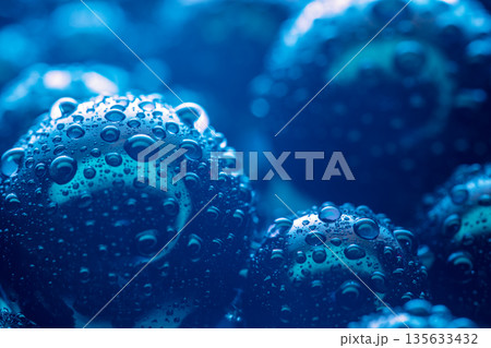 A close up of a blue sphere with many small droplets of water on it A close up of a blue sphere with many small droplets of water on it 135633432