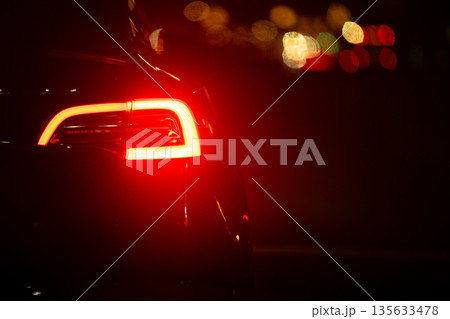 A car with its lights on and the back of the car is lit up A car with its lights on and the back of the car is lit up 135633478