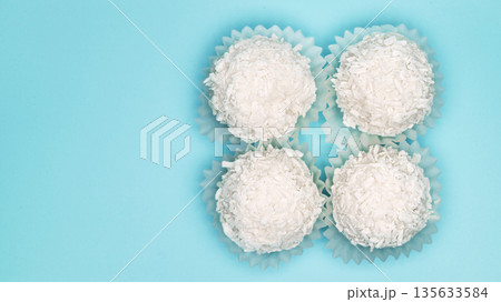 Four white coconut balls in a row 135633584