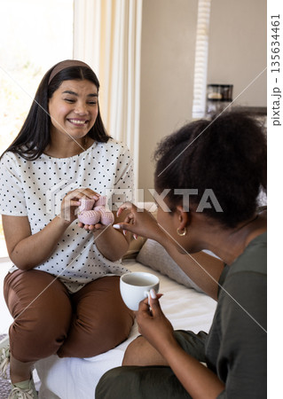 Friends sharing pastries and coffee at home, enjoying cheerful conversation Friends sharing pastries and coffee at home, enjoying cheerful conversation 135634461