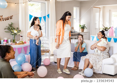 Celebrating baby shower, women sharing joyful moments with balloons and gifts together Celebrating baby shower, women sharing joyful moments with balloons and gifts together 135634543