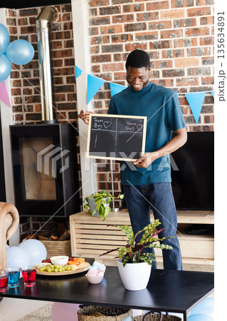 Man holding chalkboard with Team Boy and Team Girl at gender reveal party Man holding chalkboard with Team Boy and Team Girl at gender reveal party 135634891