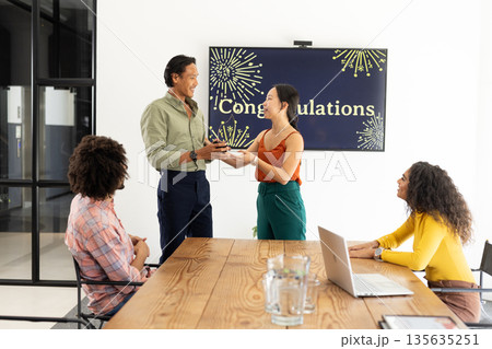 Celebrating achievement, colleagues presenting award with smiles and applause in office Celebrating achievement, colleagues presenting award with smiles and applause in office 135635251