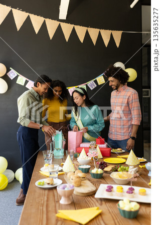 Celebrating birthday with cake and decorations, colleagues in office gathering together Celebrating birthday with cake and decorations, colleagues in office gathering together 135635277