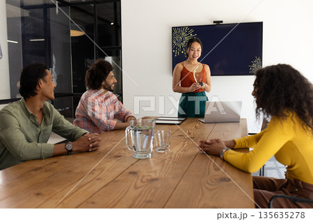 In modern office, business team collaborating and discussing project, smiling together 135635278