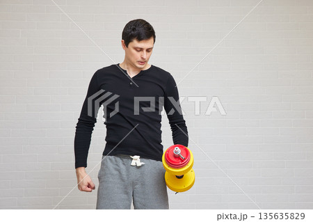 Man holding dumbbell in hand, reflecting on home exercise 135635829