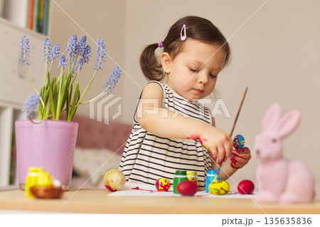Little child girl paint Easter eggs at home. kid is preparing for Easter. Little child girl paint Easter eggs at home. kid is preparing for Easter. 135635836