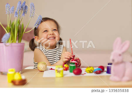 Little child girl paint Easter eggs at home. kid is preparing for Easter. Little child girl paint Easter eggs at home. kid is preparing for Easter. 135635838