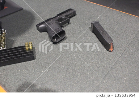 A pistol and a clip on the table. The concept of preparing a murder. 135635954